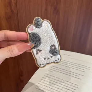 Macro view of a soft plush cartoon cat embroidery patch for hair styling and accessory.