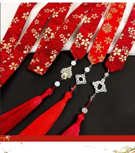 Detail view of red Chinese Hanfu hair ribbons with gold patterns and tassels