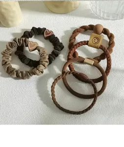 Close-up of durable earth-tone elastic hair ties with heart and smiley face charms