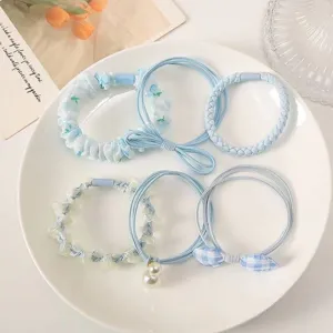Set of five light blue aesthetic hair ties and scrunchies displayed on a white plate.
