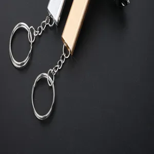Close-up detail of double-hole metal survival whistle keychain, portable camping tool