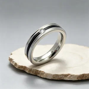 Primo piano di un anello minimalista in acciaio titanio con scanalatura nera e uno zircone.