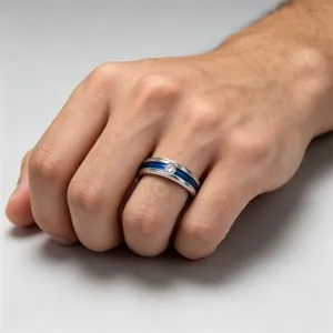 Primo piano dettagliato di un anello in acciaio inossidabile con scanalatura blu e cristallo.