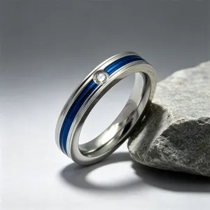 Dettaglio anello di coppia in acciaio inossidabile, scanalatura blu e singola pietra zircone.