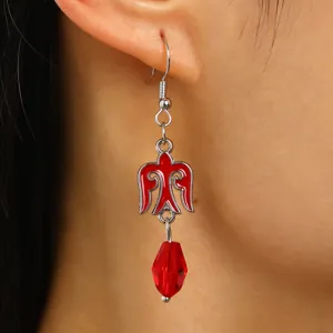 Detailed close-up of a Kazakh ethnic style red wing earring with crystal bead drop