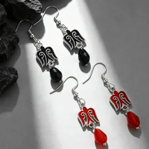 Detail shot of Kazakh-style wing earrings with faceted teardrop beads in red and black.