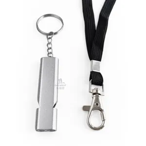 Detail shot of metal survival whistle with black lanyard and keyring, durable outdoor gear.