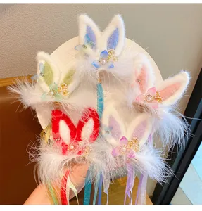 Close-up of cute plush bunny ear hair clips with tassels for kids hanfu