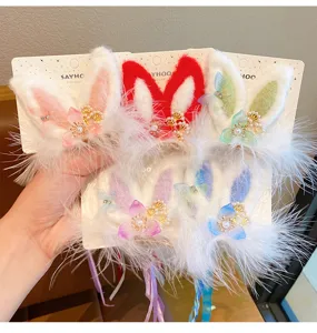 Detailed view of colorful plush rabbit ear hair clips with flowers and tassels for girls