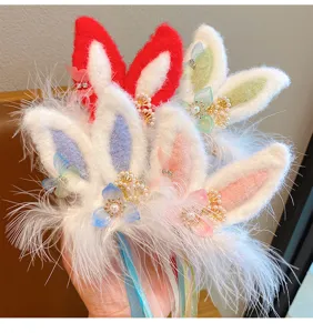 Close-up of cute plush bunny ears hair clips with feathers and floral details