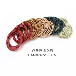 Close-up of multicolor seamless thin elastic hair ties arranged in a neat curved row