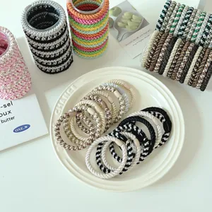 Close-up of colorful woven high-elastic hair ties on a white ceramic plate detail