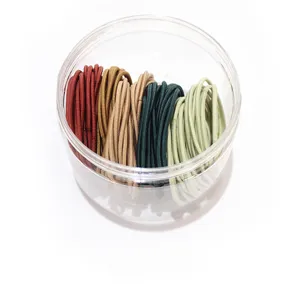 Seamless slim elastic hair ties in assorted earthy tones stored in a clear container