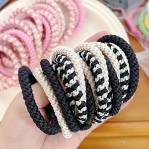 Detailed macro shot of thick braided high-elastic hair ties in black and beige tones