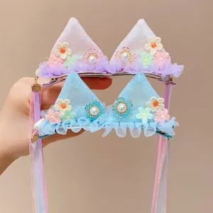Detail view of cat ear hair clips featuring floral embroidery and long mesh ribbons
