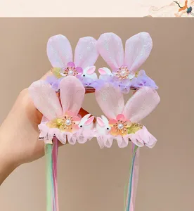Macro view of sparkly pink bunny ear hair clips featuring elegant long ribbons
