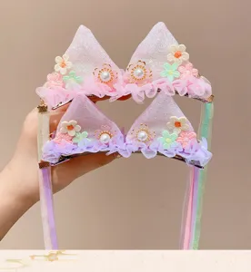 Close-up of cute fairy-style hair clips with lace flowers and long ribbons for girls.