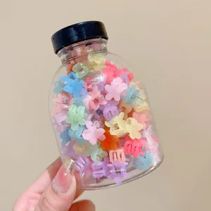 Close-up of vibrant colorful flower-shaped mini hair clips stored in a transparent jar