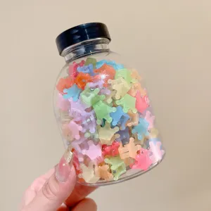 Transparent jar filled with colorful mini crown hair clips for kids and toddlers