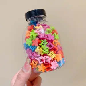 Macro view of colorful mini flower hair clips for kids packed in a transparent jar