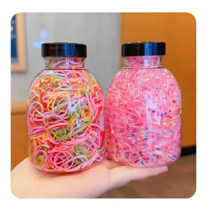 Detailed macro view of two jars filled with colorful and pink speckled elastic hair bands