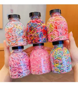 Detailed view of colorful elastic hair bands in six clear mini bottles for kids.