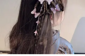 Gros plan de pinces à cheveux papillon avec tresses synthétiques et glands pour filles