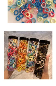 Detail showing various colors of children's elastic hair bands in storage bottles