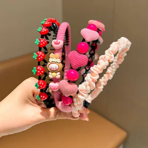 Close-up of colorful children's headbands with pearls, strawberries, and cute charms