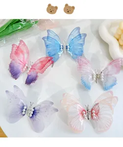 Detailed view of moving butterfly hair clips with pearls in five gradient colors