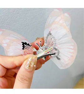 Detailed macro view of a moving butterfly hair clip with delicate translucent pink gauze wings