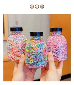 Detailed view of three jars filled with colorful disposable high elasticity hair bands