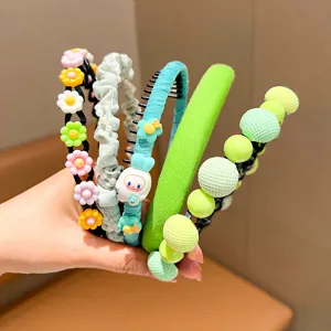 Close-up showing a collection of colorful children's headbands with floral and pearl accents