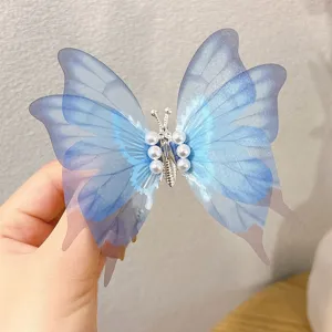 Close-up detail of a blue translucent fabric butterfly hair clip decorated with white pearls