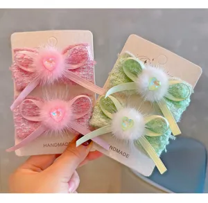 Detailed view of French style tweed hair clips with soft mink fur and heart gems.