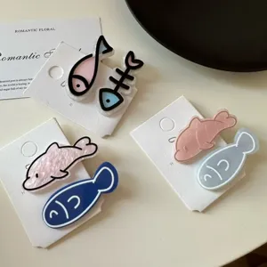 Close-up of cute cartoon fish and fishbone acrylic duckbill hair clips for girls.