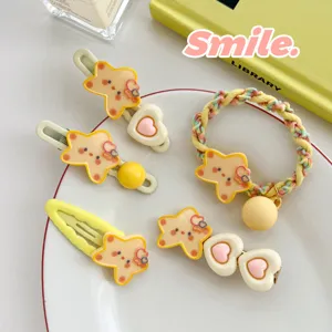 Detail view of cute star-patterned hair clips and a braided hair tie on a white plate