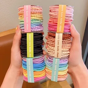 Detail of colorful elastic hair bands in cylindrical packaging for girls