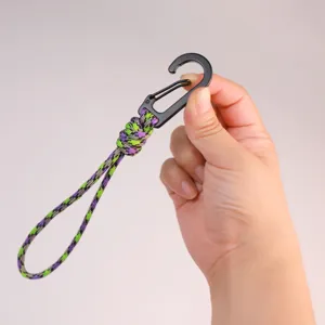 Hand-woven paracord keychain lanyard detail, purple green camp style quick draw carabiner.