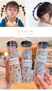 Close-up of colorful baby elastic hair ties in clear bottles with child model view
