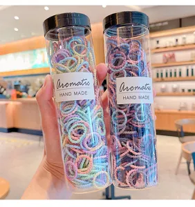 Close-up of colorful baby hair ties packed in transparent bottles