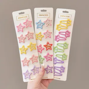 Close-up view of colorful star-shaped snap hair clips on white cardboard packaging cards
