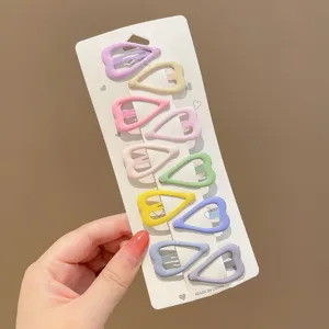 Detailed view of ten heart-shaped pastel hair clips organized on a white display card.