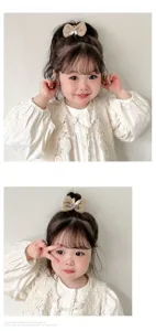 Détail d'un joli chouchou beige avec nœud et motif lapin sur les cheveux d'une petite fille