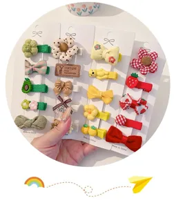 Close-up detail of various cute fabric-wrapped hair clips for baby girls in a set