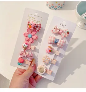 Detailed view of assorted cute pastel cloth-covered hair clips for toddlers and baby girls