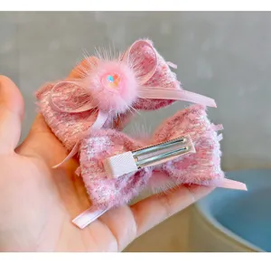 Close-up detail of pink tweed bow hair clips with soft mink fur and heart gem