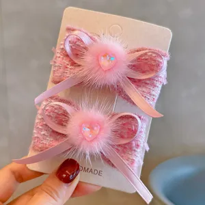 Detail view of pink faux mink fur heart bow hair clip for girls with tweed fabric texture
