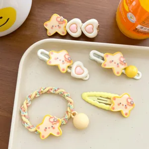 Cute yellow star and pink heart hair accessories set presented on a white tray