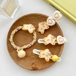 Cute yellow star hair clips and scrunchie set displayed on a rustic wooden tray